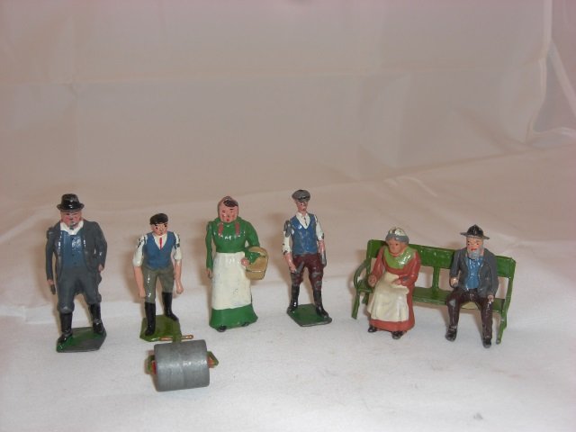Britains Civilians with Bench: With Farmer #501, Farmer's Wife #502, Stable Lad #563, Man with Garden Roller #715, Old Man Sitting #555, and Old Woman Sitting #556 on Garden Seat #568. 8 Pieces. Condition Excellent; Farmer #501 is 