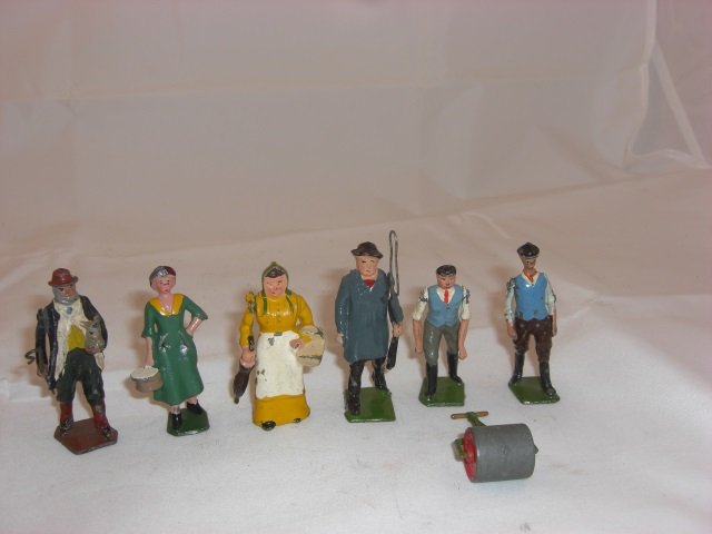 Britains Civilians: Farmer with Lamb #594, Milkmaid #532, Farmer's Wife with Umbrella #503, Carter with Whip #505, Man with Roller #715, and Stable Lad #563. 7 Pieces. Condition Excellent.