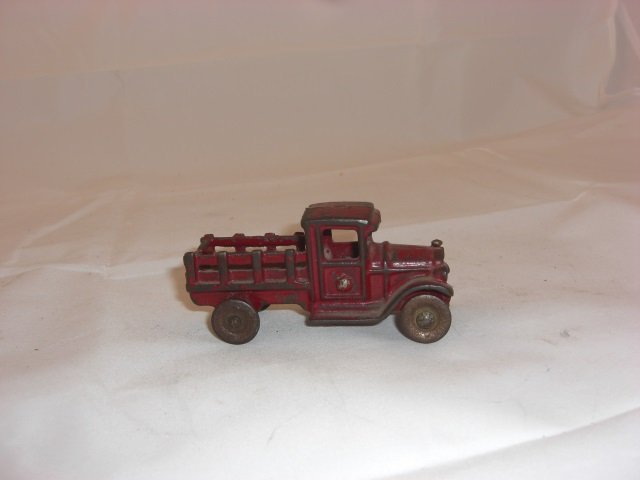A. C. Williams Cast Iron Open Stake Bed Truck: With Metal Wheels. 3 1/2 Inches long. 1 Piece. Condition Good.