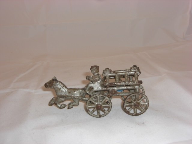 Cast Iron Horse-Drawn Fire Wagon: With Fixed Ladders. 5 3/8 Inches long. 1 Piece. Condition Very Good.