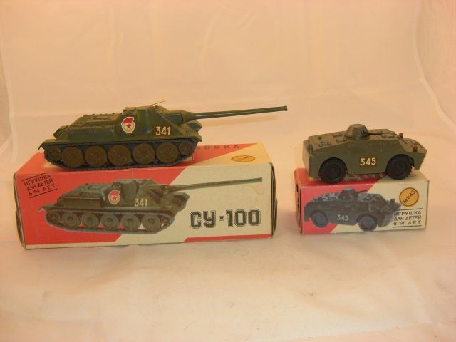 Russian Made Vehicles: Includes Tank Measuring 9 1/4 Inches by 3 Inches by 2 7/8 Inches and Armored Car Measuring 2 1/4 Inches by 1 3/4 Inches by 7 Inches. 2 Pieces. Condition Mint in Box.
