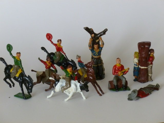 Crescent Rodeo Cowboys: Cowboy and Cowgirl Prisoner, Cowboy Seated with Banjo, Cowboy Sleeping, and a Timpo Cowboy Tied to a Tree. 9 pieces. Post War, unboxed, condition very good