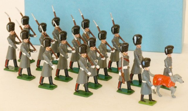 The Guards Toy Soldier Center: Irish Guards with officers, colour Sargent, Irish Wolf Hound Mascot and handlers. 17 pieces. With a number of original boxes. Condition excellent. Boxes Excellent.