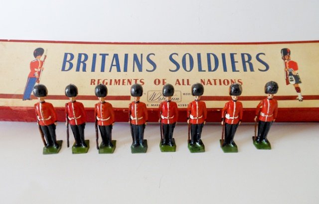 Britains Set #2082 Coldstream Guards: At attention. Post War. 8 pieces. No officer. Untied in an original R.O.A.N. box. Tie card water damaged. Condition excellent. Box good.