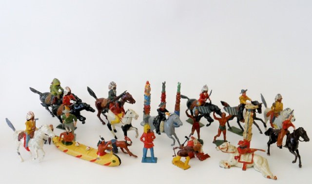 Britains and Cherilea Wild West Assortment: Cowboys and Indians, Britains Cherilea and Johillco mounted and on foot, totem poles, and RARE two Indians in a canoe by Cherilea. 24 pieces. Condition very good. Unboxed.