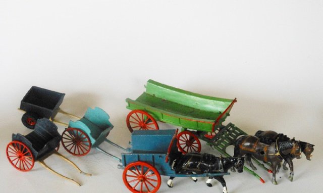 Britains Farm Assortment: Pre-War and Post War. Four-wheel wagon (no tail board), Farm Cart with rubber tires, Two Milk Floats, and a Tumbril Cart (no tail board or racks). 5 pieces. Unboxed. Condition Good to Fair.