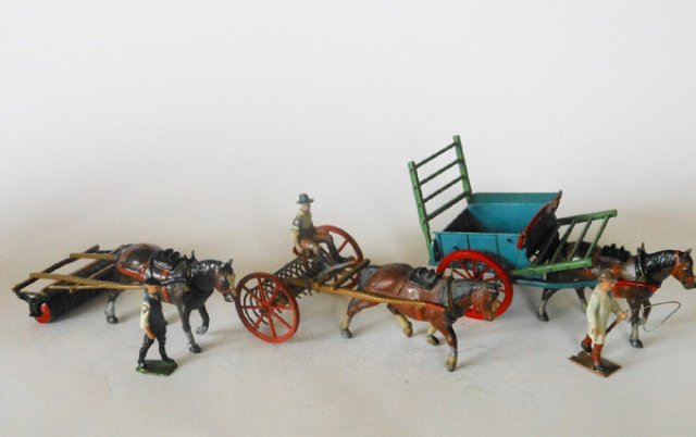 Britains Farm Implements: Pre-War Tumbril Cart (no racks), Pre-War Horse drawn rake, and Post War Horse drawn roller. 3 pieces. Unboxed. Condition good.
