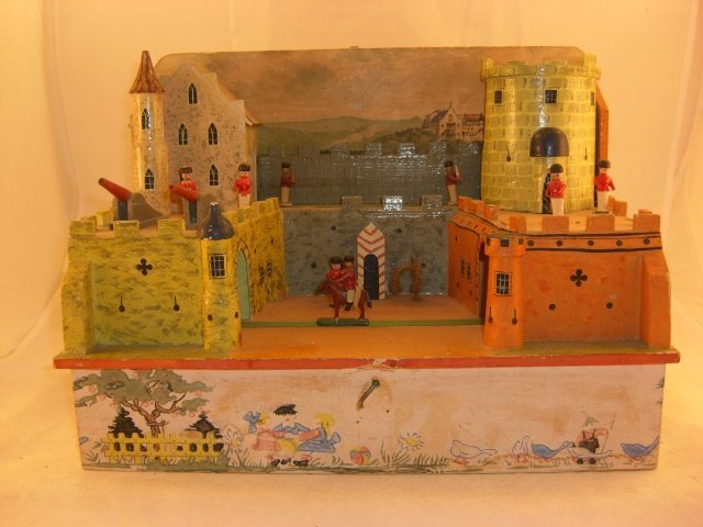 Castle Music Box: Castle/Music Box; wooden, wooden figures glued on; base 14” x 8” x 10 1/2” tall; some damage to crenellations on right-hand tower; figures in middle rotate on cloth tape through castle as music
