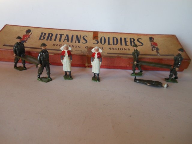 Britains Set #1723 Royal Army Medical Corps Unit: 5 pieces. 2 stretchers manned, one patient, and 2 nurses. Post War. Untied. Retaining card inside original R.O.A.N. box. Condition excellent. Box fair; one corner of lid split, tape on lid, and small 