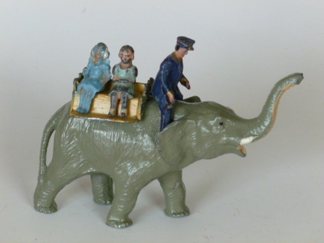 Barrett & Son Elephant Ride: Elephant with seated Keeper, Howdah, 2 girl riders, (one is incorrect for the set). 5 pieces. Post War. Condition very good.