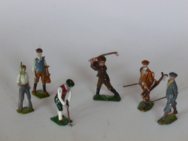 Britains and Johillco, etc. assorted Golfers: Britains #562 Golfer in grey; #562 Golfer in brown with reproduction golf bag and clubs; Johillco Golfer Teeing off; plus 2 converted caddies and a golfer putting. Pre-War and Post War. 6 pieces. Unbo