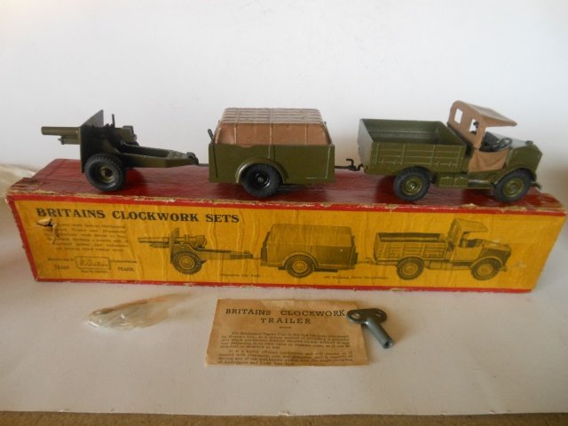 Britains set #2048 Clockwork set: Beetle Lorry Clockwork trailer and 25 pounder gun. 3 pieces. Post War. In original illustrated box. Condition excellent. Box good. (both ends of lid split and edges of lid slightly frayed)