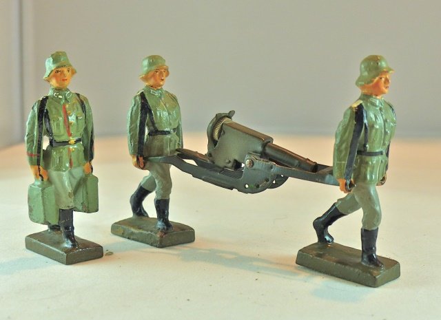 Lineol 3 German Soldiers w/Machine Gun: The gray camouflage machine gun has no wear and cocks and fires normally. The soldier with the ammo boxes has a couple of small paint chips to the ammo boxes with hardly any wear. The other two soldie
