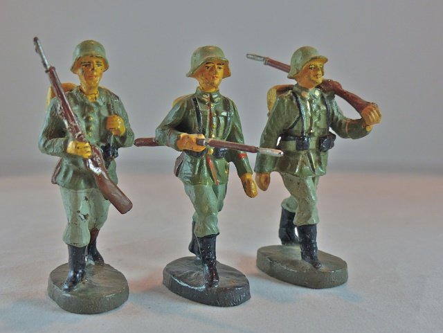 Elastolin 3 Germans March w/Rifles: Just a couple of small minor cracks with some light paint wear. Excellent faces, paint quality and equipment detail. 3 Pieces. Rifle across chest made 1935-38. Other 2 made 1936-40. Condition excellen
