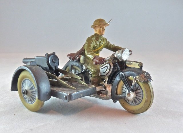 Lineol Motorcycle w/MG on Sidecar US Soldier: Couple of small paint chips to gray frame of motorcycle. Movable wheels are very clean with hardly any wear. Driver has a thin partial neck crack with hardly any paint wear. Tin plate cap firing gun h