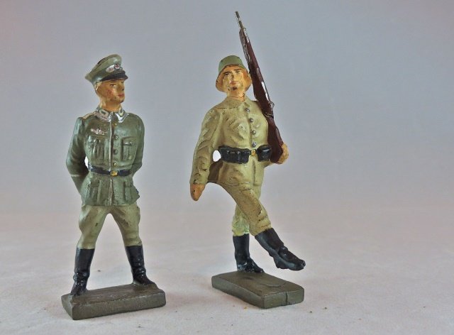 Lineol Drill Sergeant w/Goosestepping Recruit: Sergeant has a thin partial neck crack with hardly any wear. Recruit has a thin neck and leg crack with a thin glue spot by the leg crack. Faces and paint quality excellent for both pieces. 2 Pieces. 
