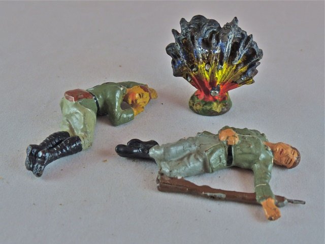 Lineol/Elastolin 2 Wounded Soldiers+Explosion: Explosion has no cracks and hardly any wear. The Elastolin wounded soldier without helmet has no cracks or apparent wear. The Lineol wounded soldier with the rifle by his side has a thin partial split