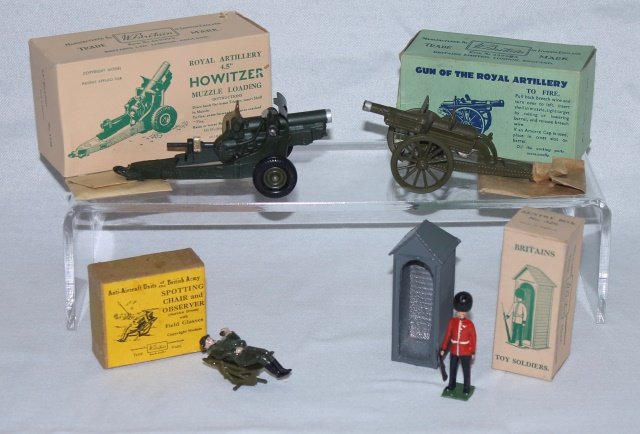 LOT Britains Guns, Spotting Chair and Sentry: Includes Britains #1292 Gun of the Royal Artillery, #1725 4.5 inch Howitzer, #329 Sentry and #1731 Spotting Chair. Post War. 6 pieces. Condition: excellent to mint, Boxes excellent.