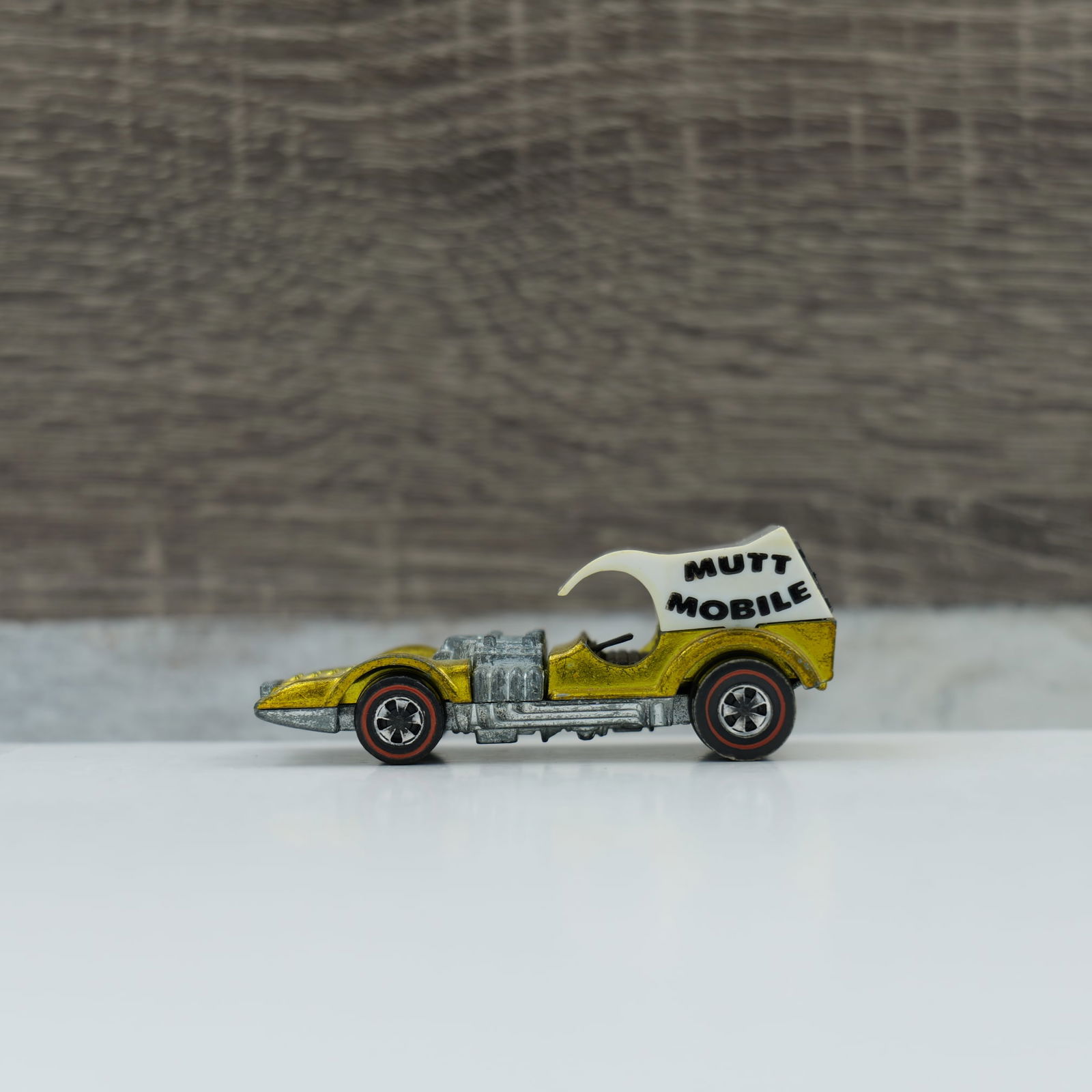 Hot wheels redline Mutt mobile: mutt mobile, gold. Light toning, some play wear engine and base are both dull. Top looks to be original with the dogs in the back