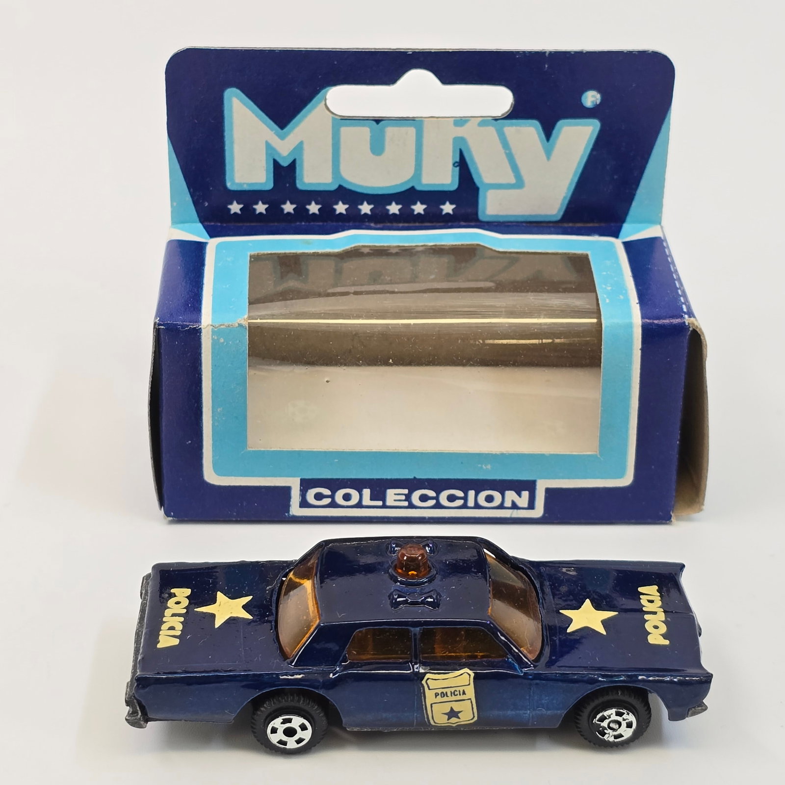 Muky Policia Cruiser: Vintage Muky Argentina #24 Policia Cruiser (1968 Plymouth Fury) w/Box Blue body, "Policia" decals, amber windows. Car- appears new in package, little to no wear. Box- is in good 