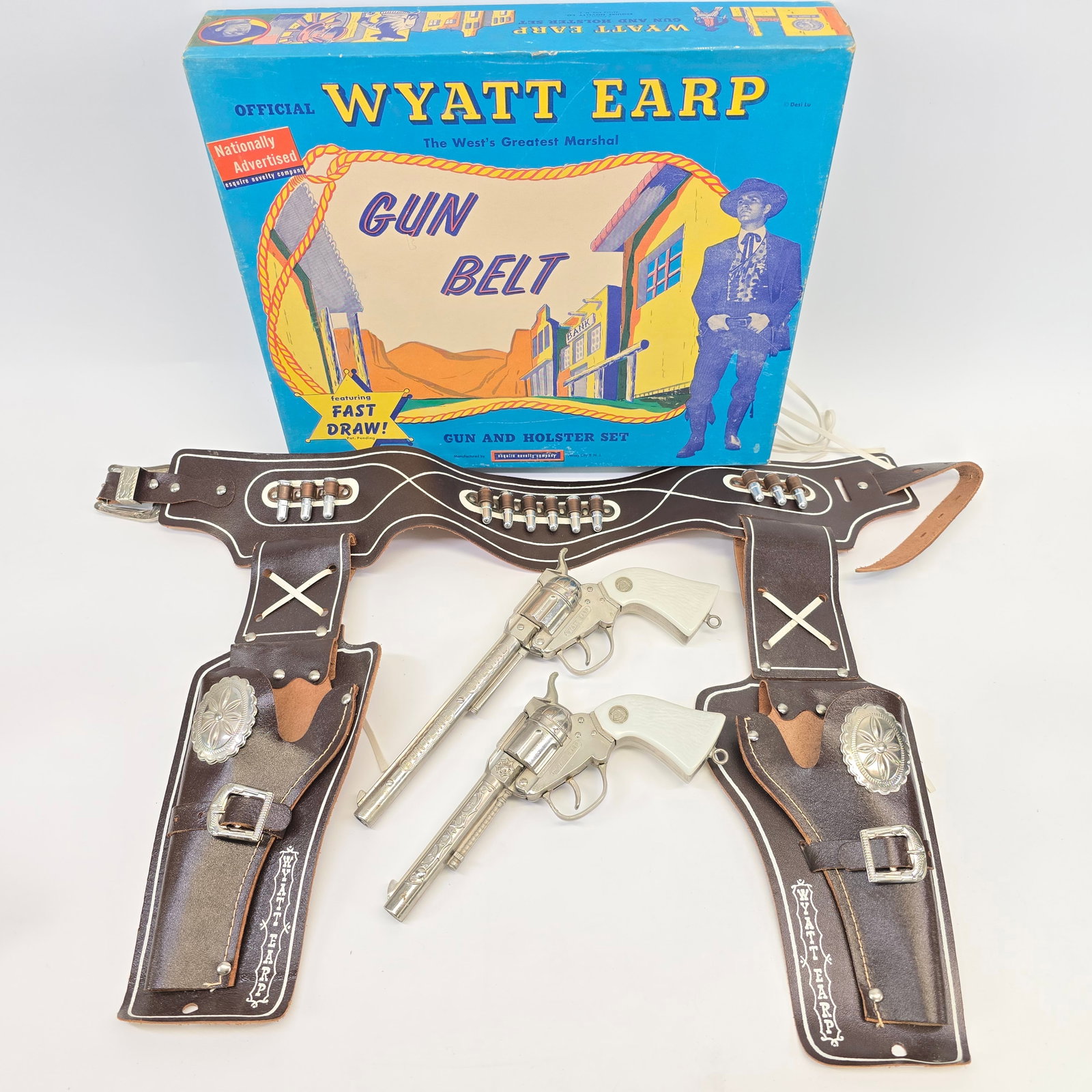 1950s Wyatt Earp Gunbelt Set: - Esquire Novelty Co., c. late 1950s - Box has faint wear in the form of some scattered color rubs. Lid has some creases at corners but remains tight w/no corner splits. - 34" leather belt w/West