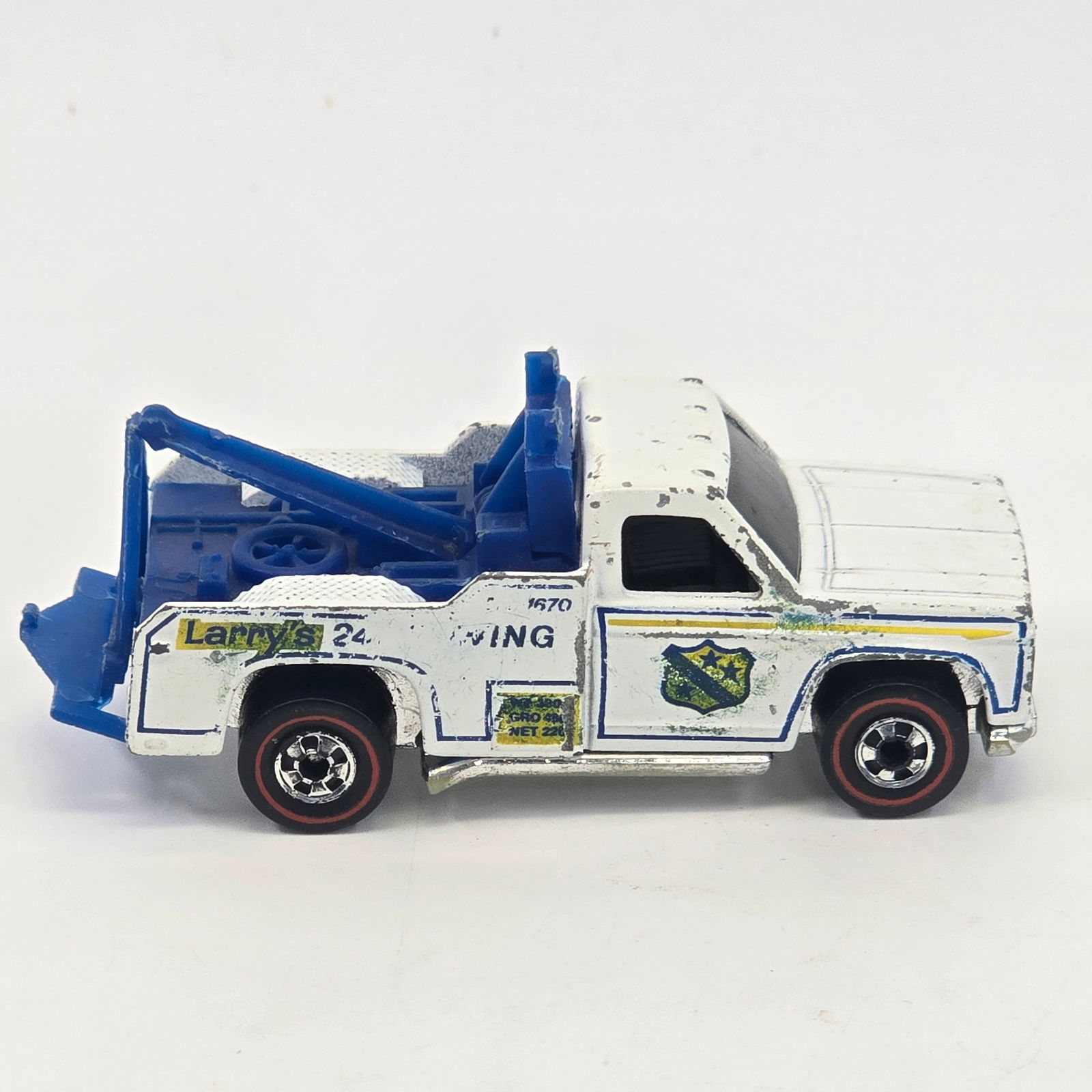 Hot Wheels Redline Tow Truck: Hot Wheels Redline Larry's Tow Truck Paint: Fair with heavy chipping and hard edge wear Tampos: Fair with wear Wheel Chrome: Good with loss as seen Glass: Good Base: good with some scrapes and loss <