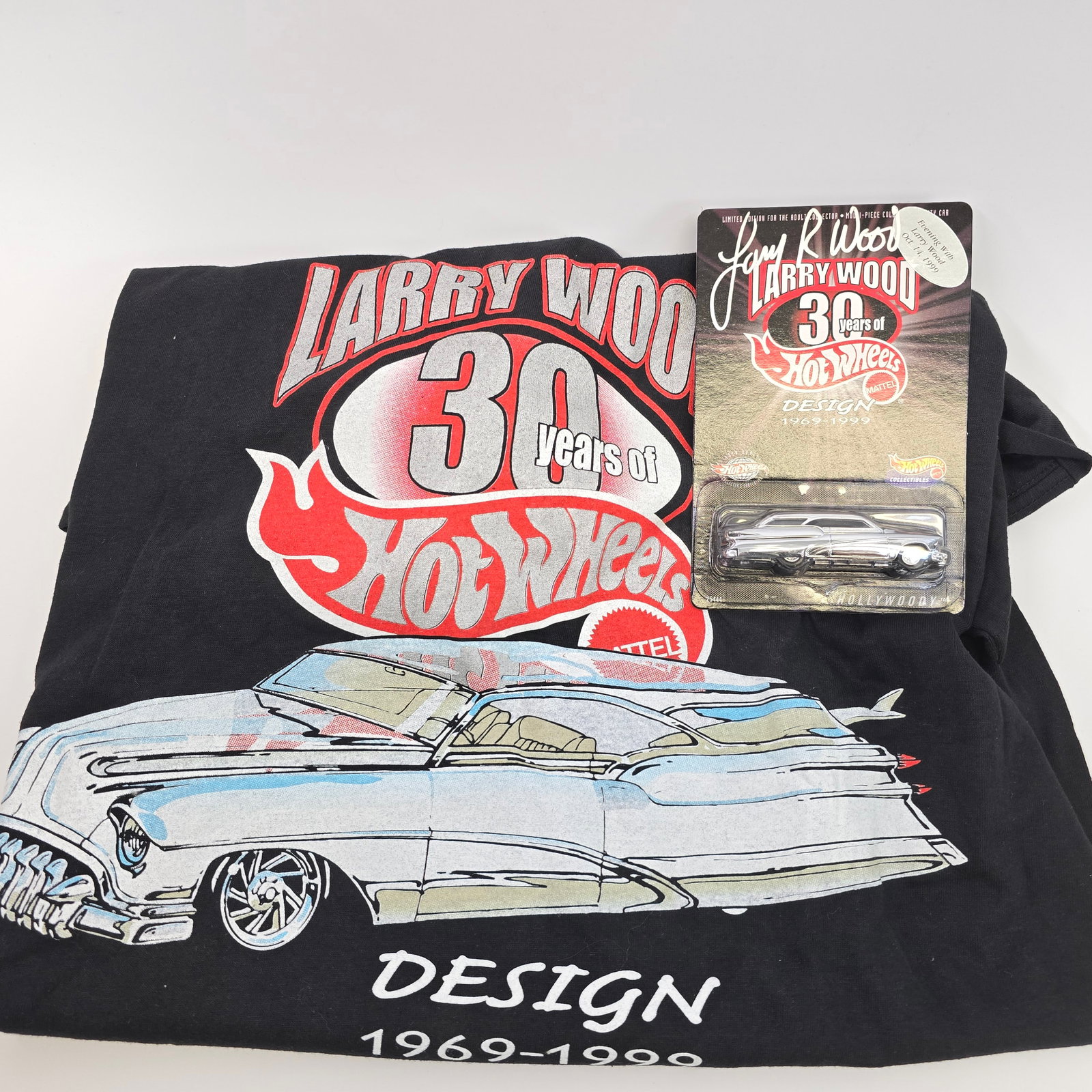 Hot Wheels Hollywoody and Tshirt: Hot Wheels Larry Wood 30 Years of Design Hollywoody Dinner car, includes car signed by Larry Wood and L size Tshirt with original tags Car: Excellent with no issues of note Card: Excellent with no iss