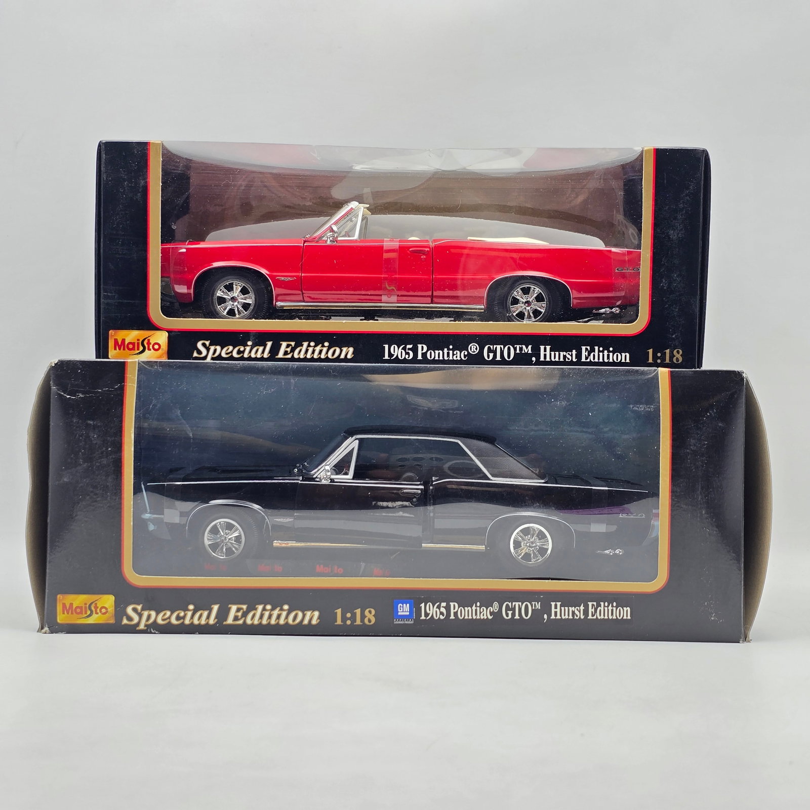 Pair of Maisto 1965 Pontiac GTO Diecast Models: Pair of Maisto 1965 Pontiac GTO Diecast Models One is red and one is Black. Scale size is 1:18. Boxes do have some shelf/storage wear. See photos for more.