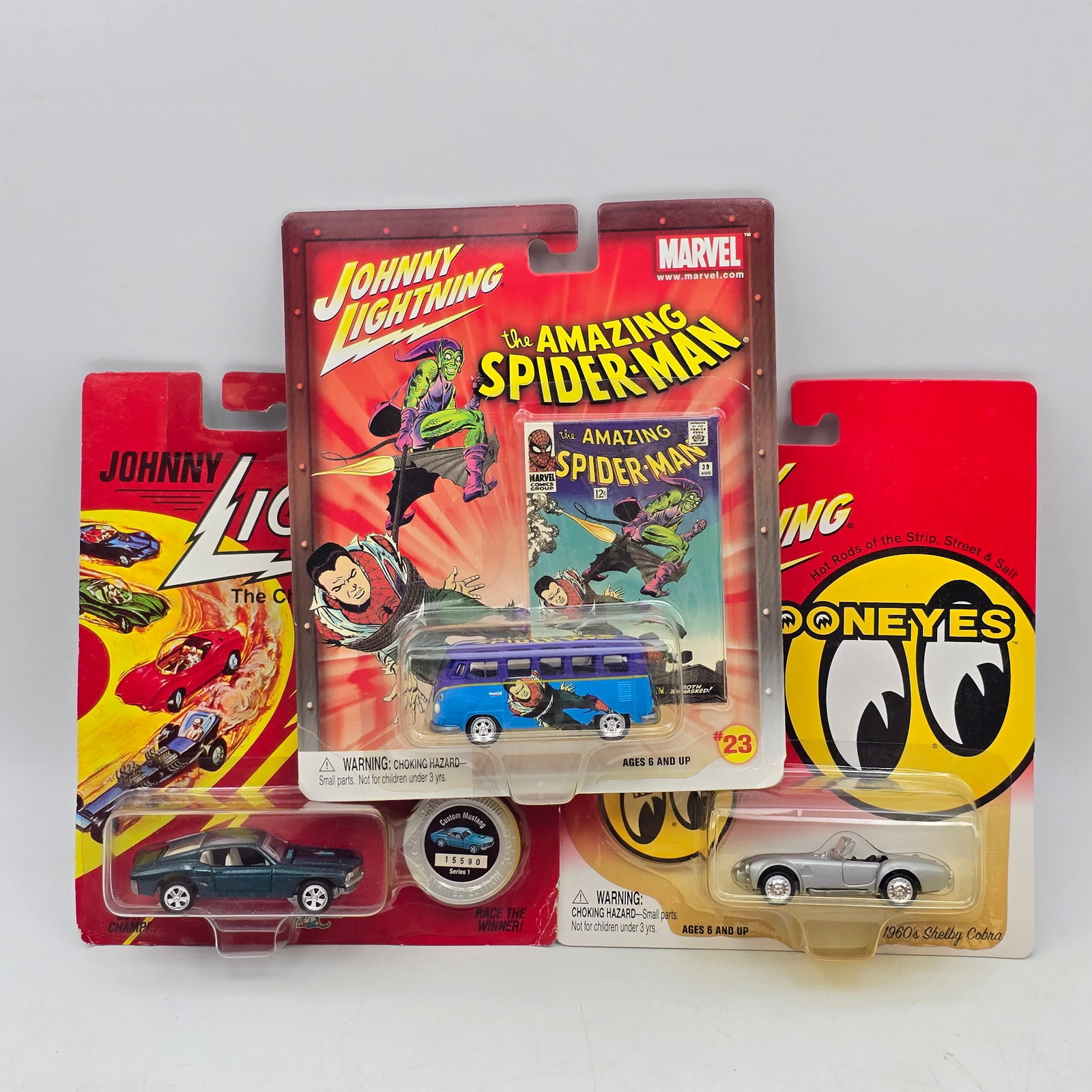 Lot of 3 Johnny Lightning Diecast: Lot of 3 Johnny Lightning Diecast Vehicles including: 1- Volkswagen Bus (Amazing Spider-Man series) 2- The Challengers Car (Commemorative series) 3- 1960s Shelby Cobra (Mooneyes series) All