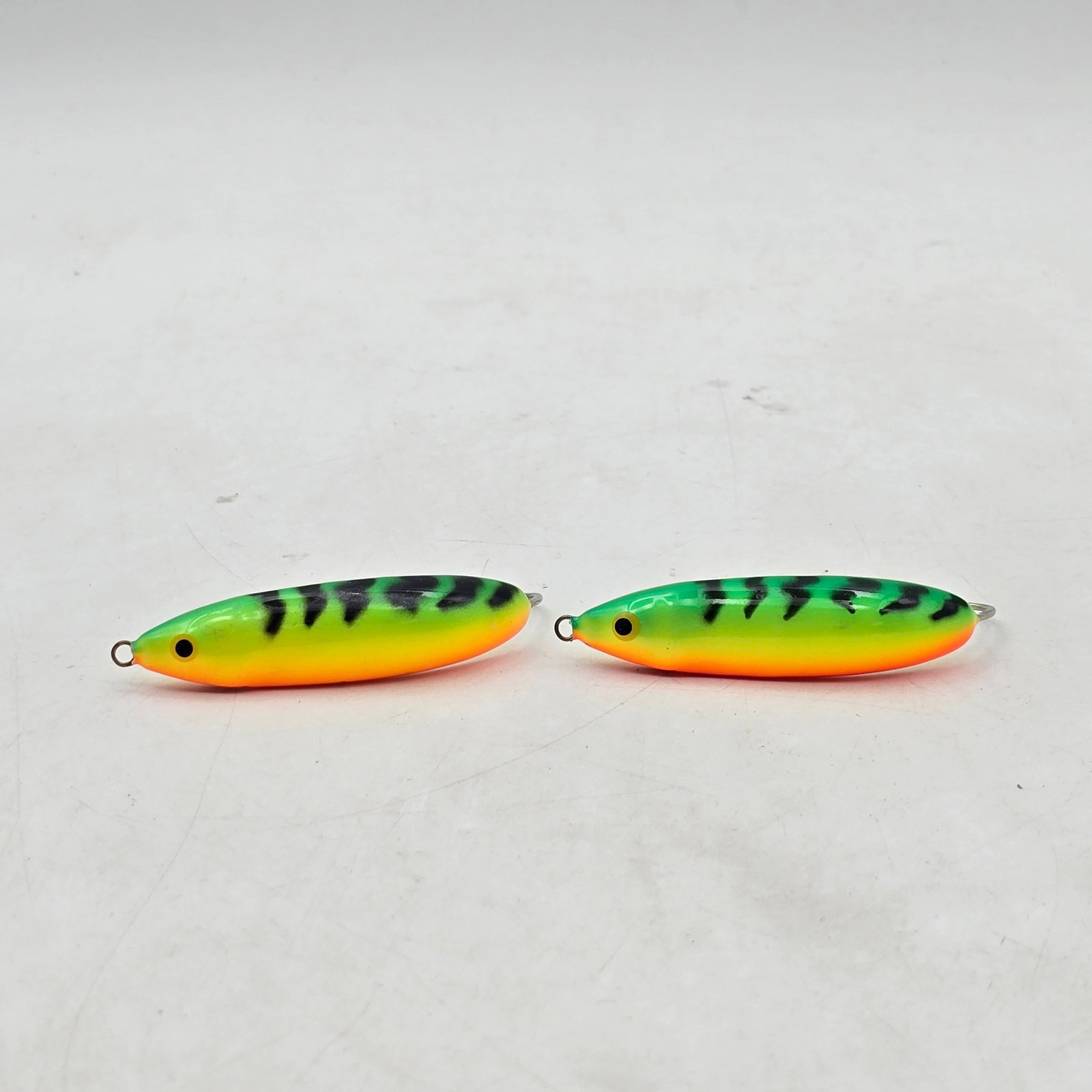 Fluke Fishing Lures: Lot of 2 Fishing Lures. Includes bright chartreuse and green patterned lures designed for high visibility in the water. They are versatile baits tailored for specific fishing scenarios to attract vari