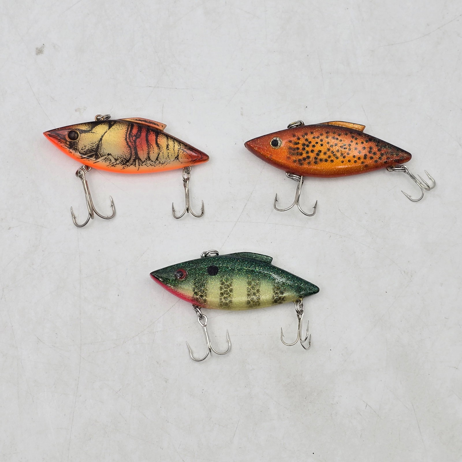 Lipless Crankbait Lures 3pc: Lot of 3 Lipless Crankbait Fishing Lures. Includes hard body lures in tiger stripe, spotted, and perch-style patterns. Lures show signs of use including wear and some hook