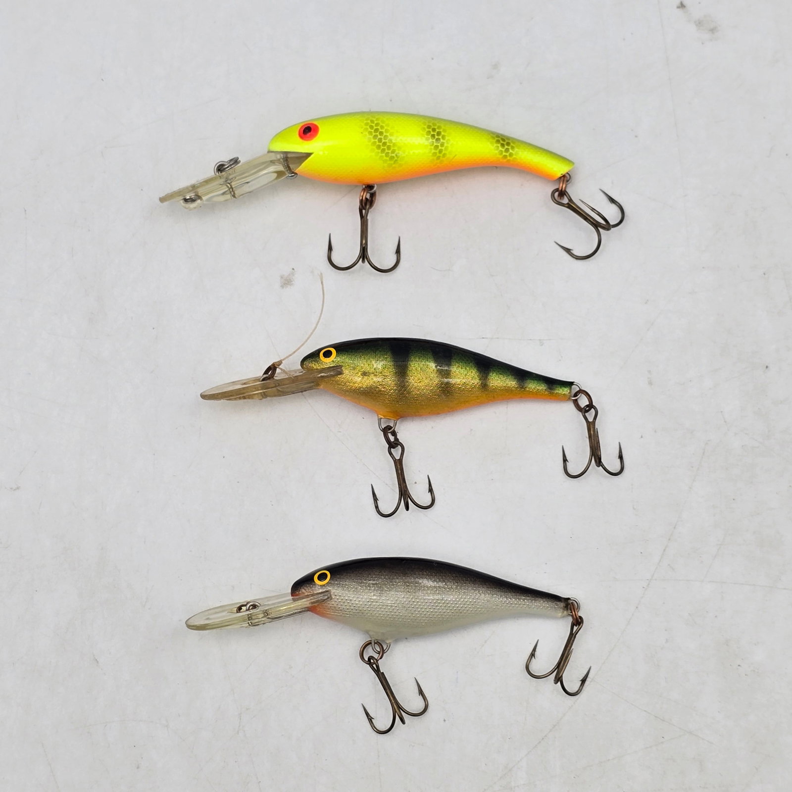 Crankbait Fishing Lures 3pc: Lot of 3 Crankbait Fishing Lures. Includes diving crankbait-style lures in chartreuse, perch pattern, and natural silver finishes. Designed for freshwater fishing with varying visibility and action.