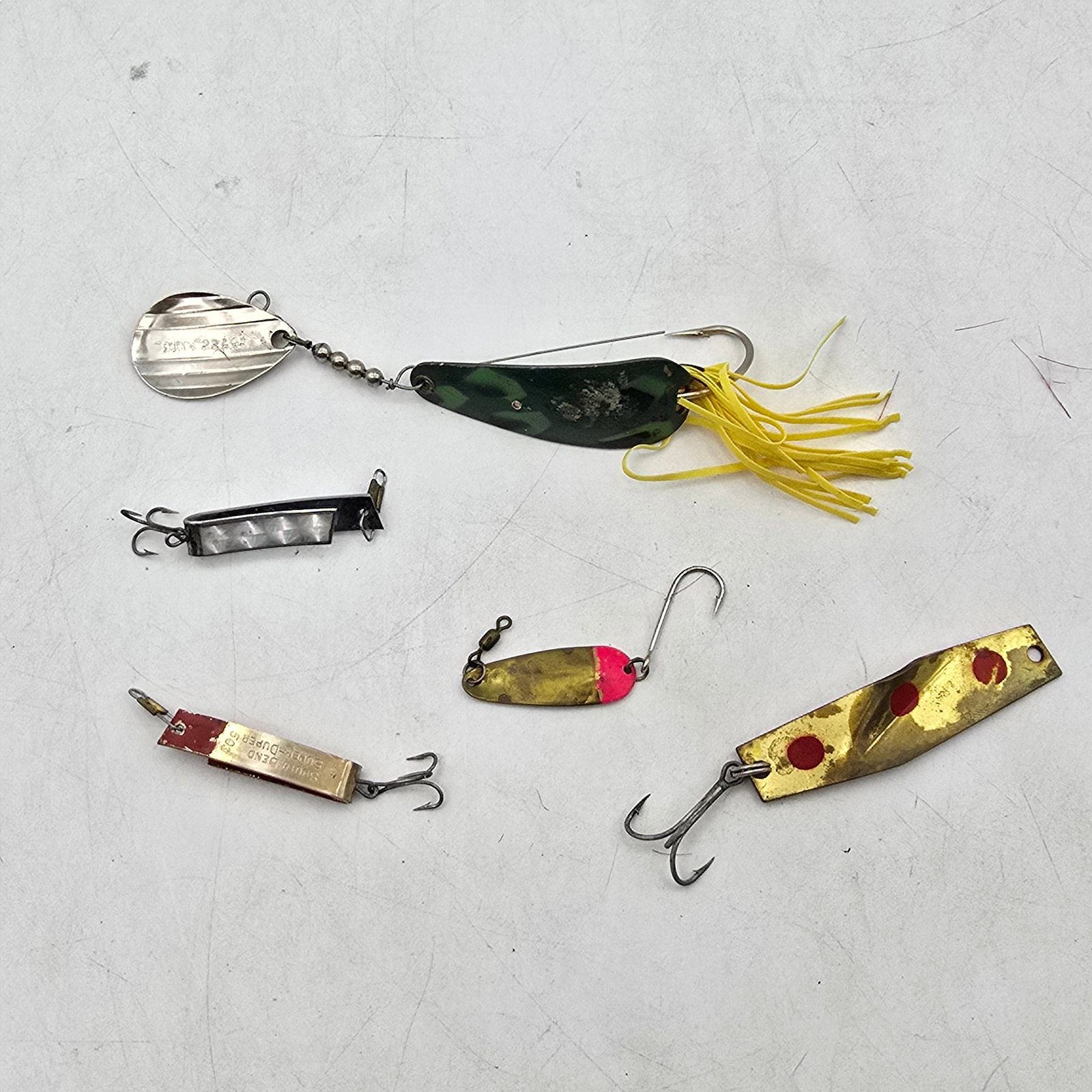 Spoon Fishing Lures 5pc: Lot of 5 Spoon Fishing Lures. Includes a variety of metal spoon-style lures in different shapes, sizes, and finishes, including a larger skirted spoon and smaller classic spoons. Designed for flash