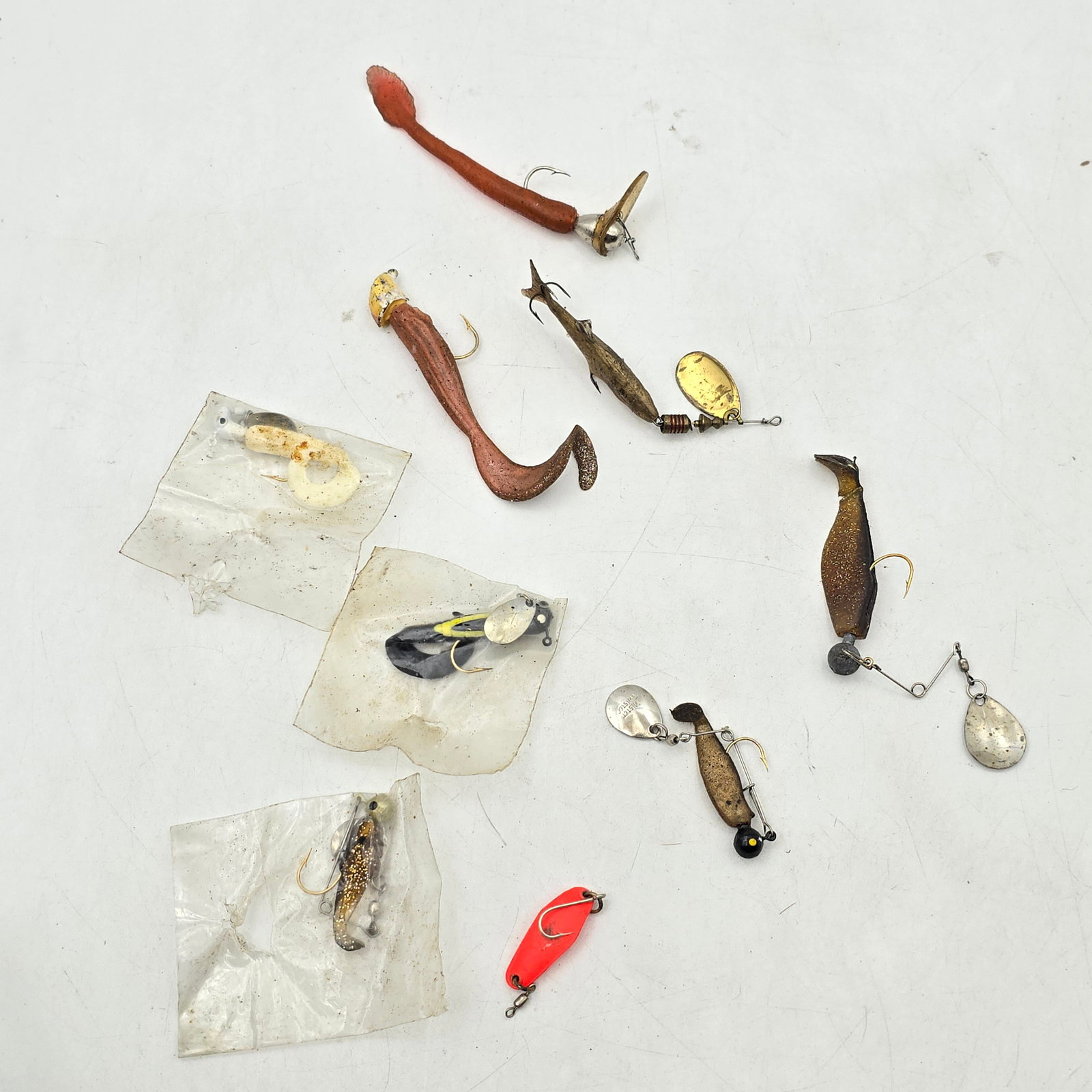 Fishing Lures Mixed Lot 9pc: Mixed Lot of 9 Fishing Lures. Includes a variety of soft plastics, spinner-style lures, and assorted rigged pieces in different styles and sizes. A mix of loose items and a few stored in small bags.