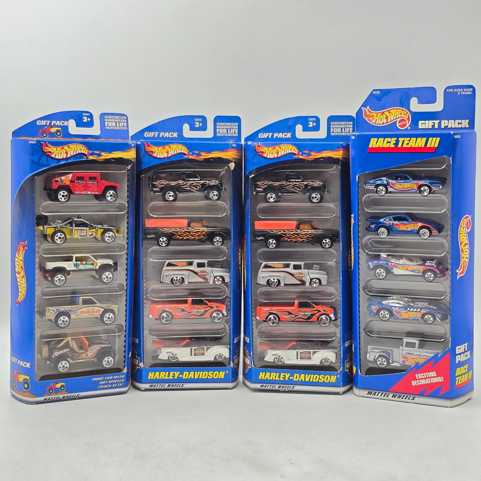 Lot of 4 HW 5 Packs: Lot of 4 Hot Wheels 5-Packs. Includes themed sets such as Harley-Davidson (multiple) and Race Team III. Each pack contains 5 vehicles for a total of 20 cars. Includes duplicates of the Harley-Davidson