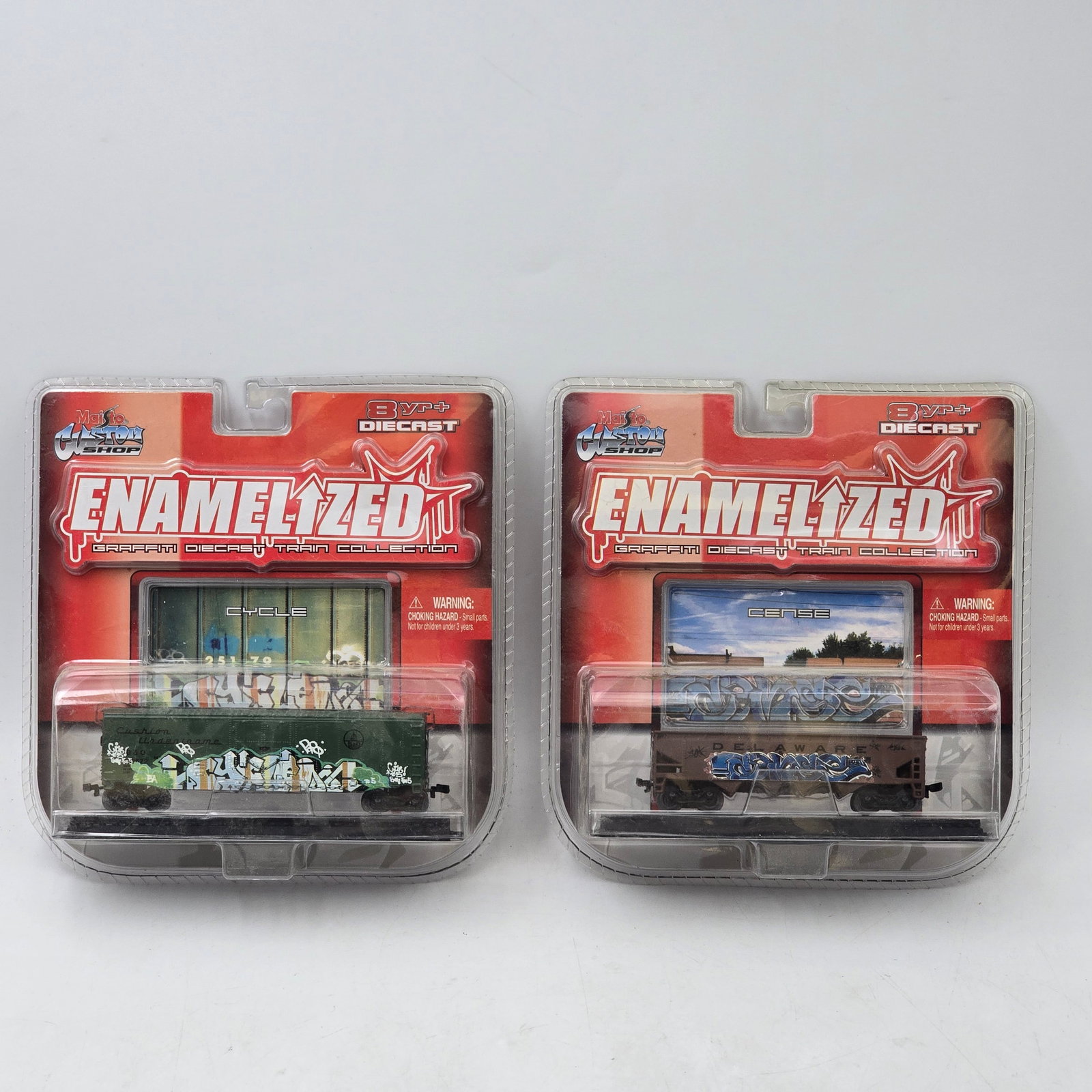 Pair of Maisto Enamelized Train Cars: Lot of 2 Maisto Custom Enamelized graffiti diecast train cars. Includes two different graffiti-style boxcar designs, part of the Enamelized series featuring detailed street art graphics. Both items ar
