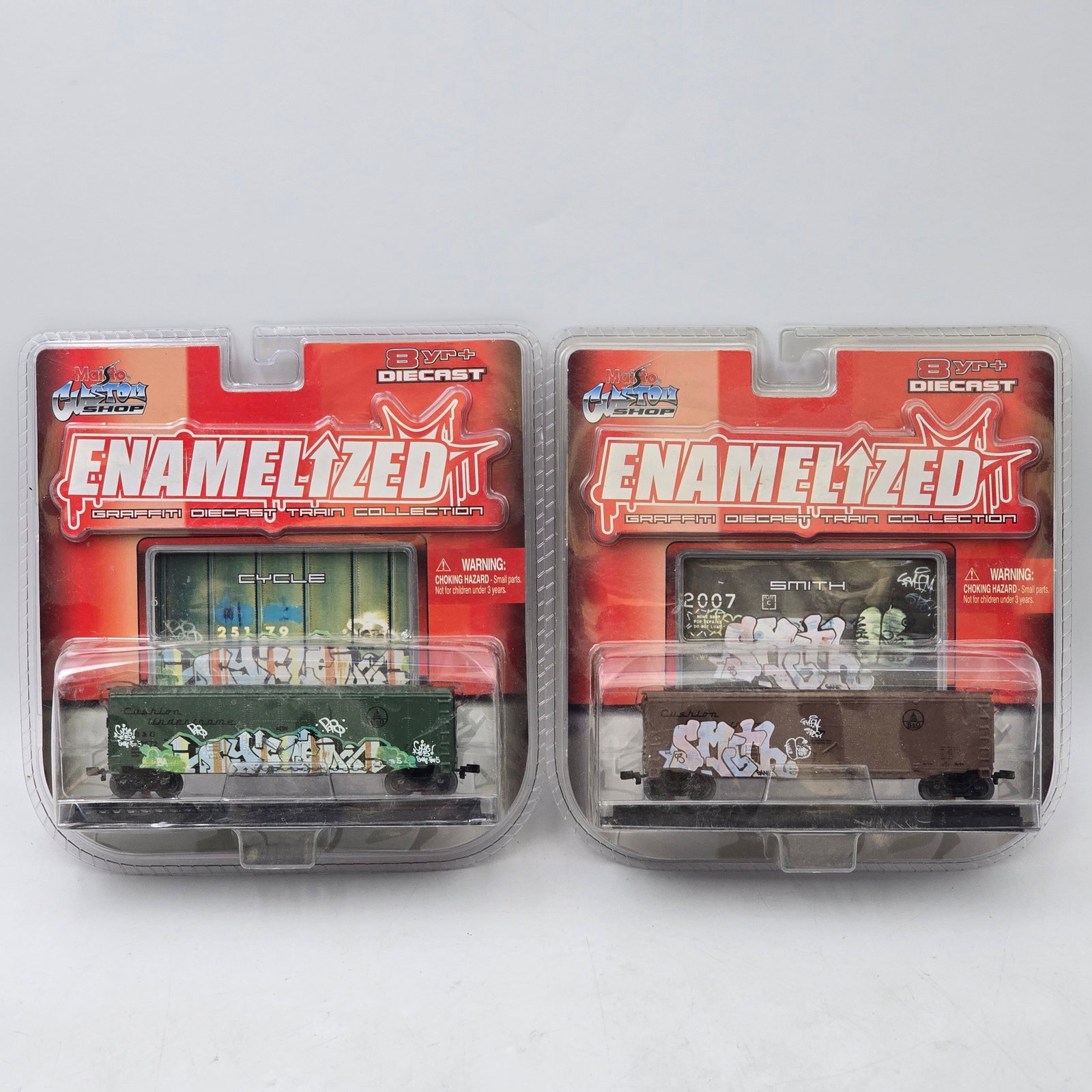 Pair of Maisto Graffiti Train Cars: Lot of 2 Maisto diecast graffiti-style train cars from the Enamelized series. Features detailed boxcars with bold street art graphics and custom-style designs. Both pieces are unopened in original pac
