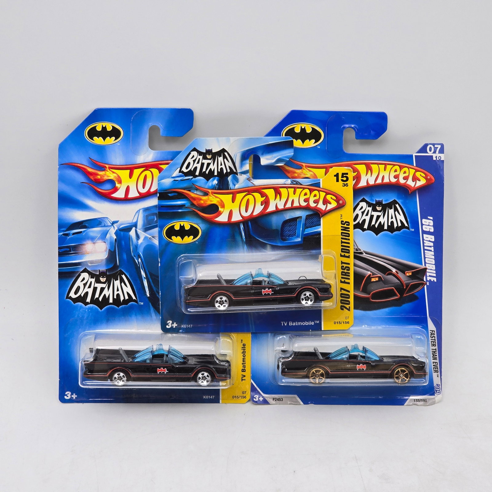 Lot Of 3 Hot Wheels Batmobile Models: Lot of 3 Hot Wheels diecast Batmobile castings. Includes classic TV-series style Batmobile models in black with red accents, featuring both standard long cards and one short card variation. All items 