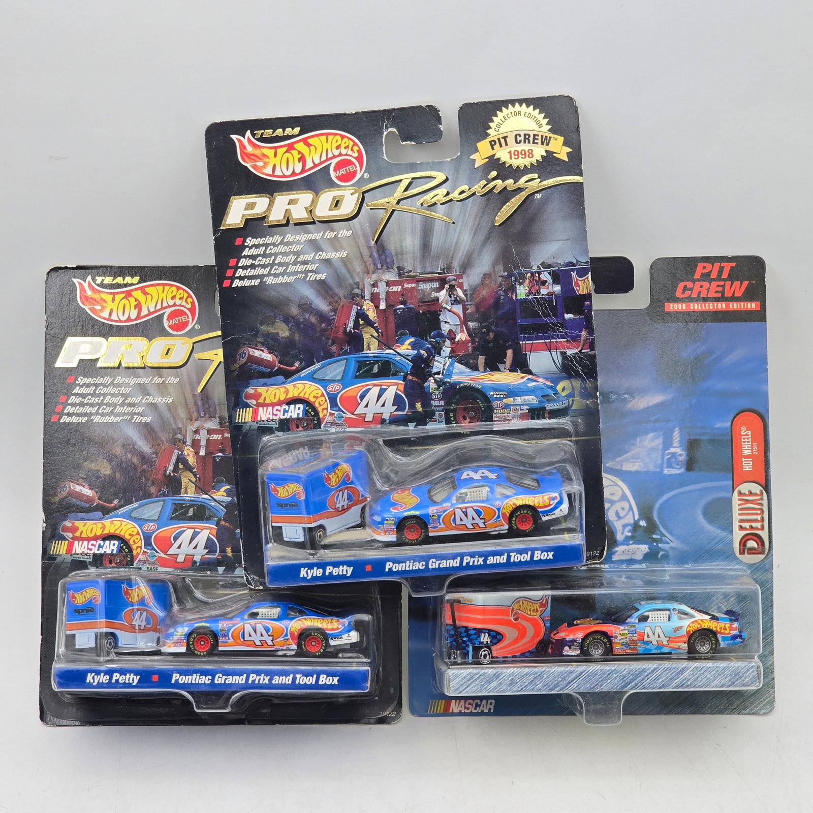 Lot of 3 Hot Wheels NASCAR Pit Crew Sets: Group of 3 Hot Wheels NASCAR-related collector releases, produced circa late 1990s to early 2000s. This assortment includes Team Hot Wheels Pro Racing Kyle Petty Pontiac Grand Prix pit crew sets along
