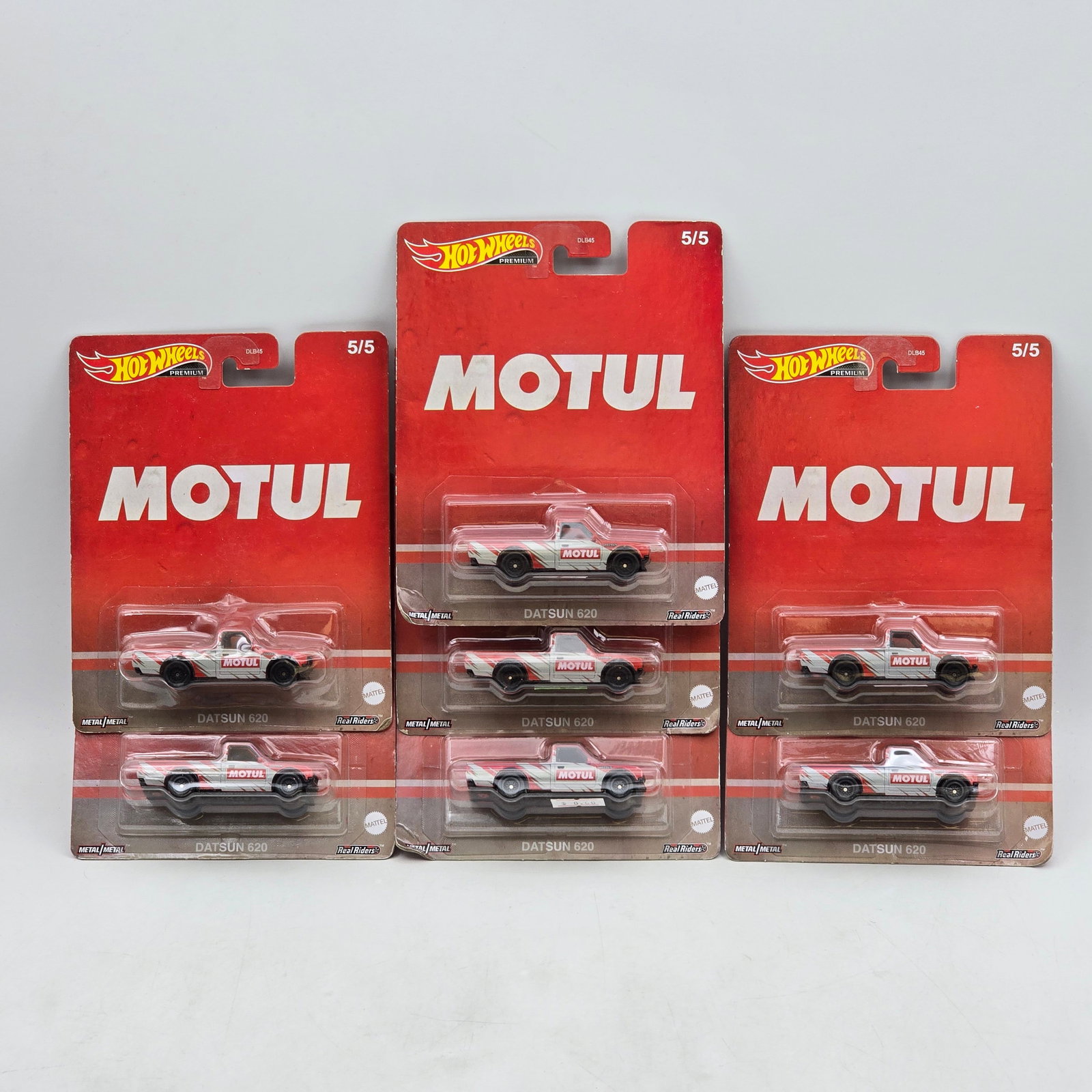 Lot of 7 Hot Wheels Premium Datsuns: Includes (7) Datsun 620 premium models from the Motul themed series. Cars-Appear to be in good condition with clean paint, sharp tampo detail, and no obvious wear visible. Cards-Show light shelf/stora