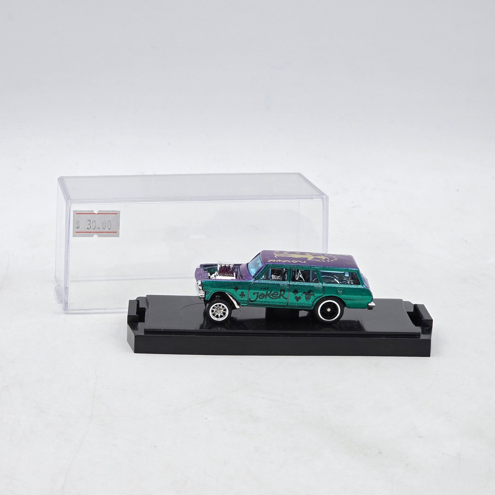 Custom Joker Wagon Diecast: Custom wagon diecast featuring striking chameleon-style paint that shifts between metallic teal, purple, and magenta tones depending on lighting angle. Includes Joker-themed graphics, exposed chrome