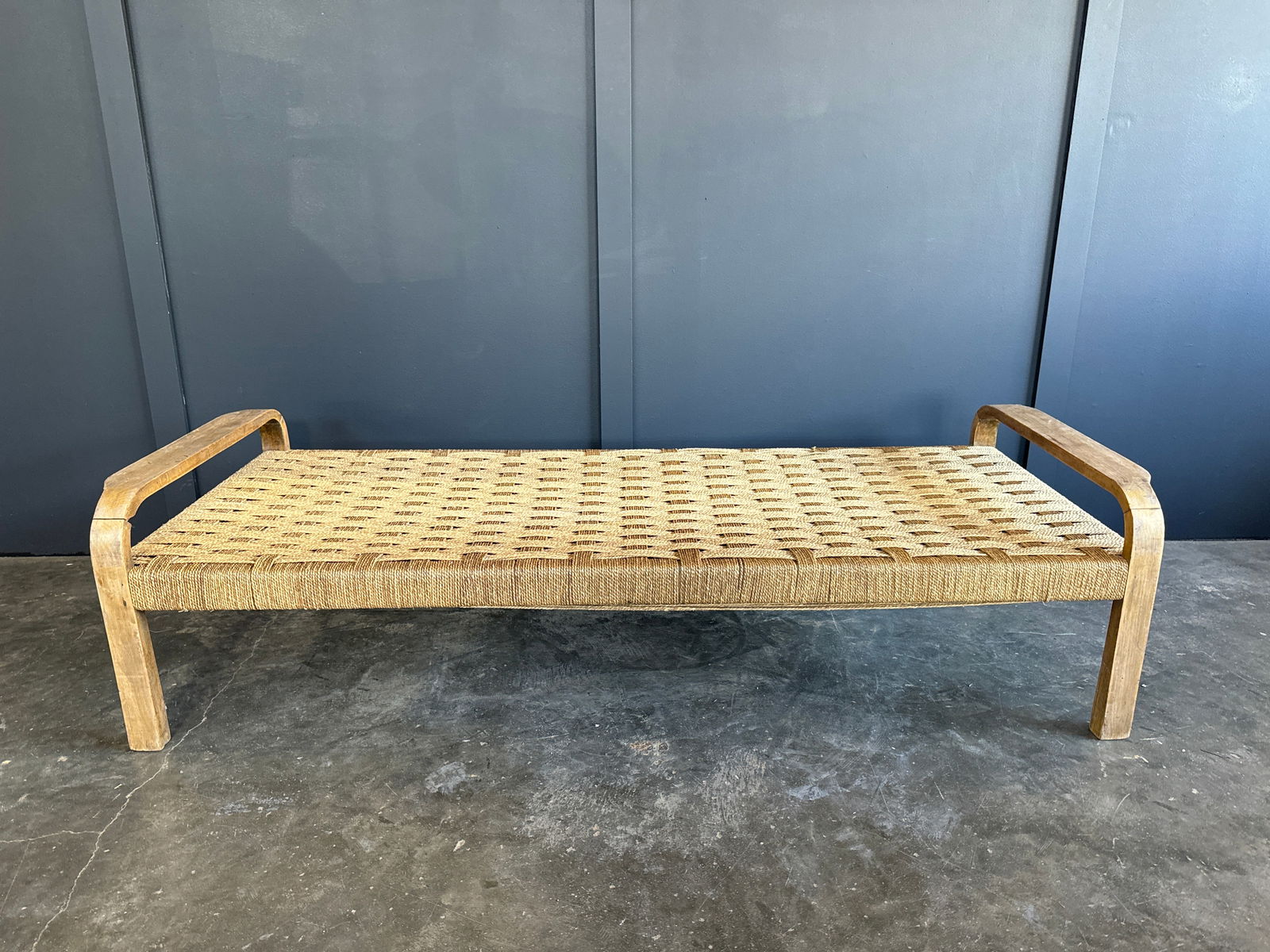 Mid Century French Woven Chaise: 31 1/2"W x 75"L x 20"H This Mid Century French Woven Chaise boasts a classic design with a sturdy wooden frame and a woven seating area. Its minimalist form is complemented by the natural materials us