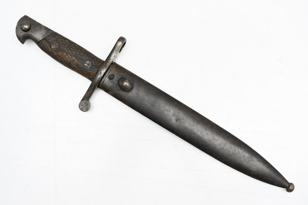 Spanish M1941 Bolo Bayonet (9.5" Blade) W/ Scabbard: This knife/bayonet is for use on the 8mm Mauser M1943 rifle. SPECS: 9.5" Blade, 14.25" overall length, checkered wooden grips and metal scabbard. MARKINGS: "A4557" on the bayonet & scabbard (numbers m