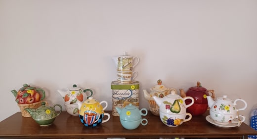 Lot of all teapots on top of cabinet