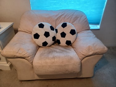 White Leather Chair with Soccer Pillows