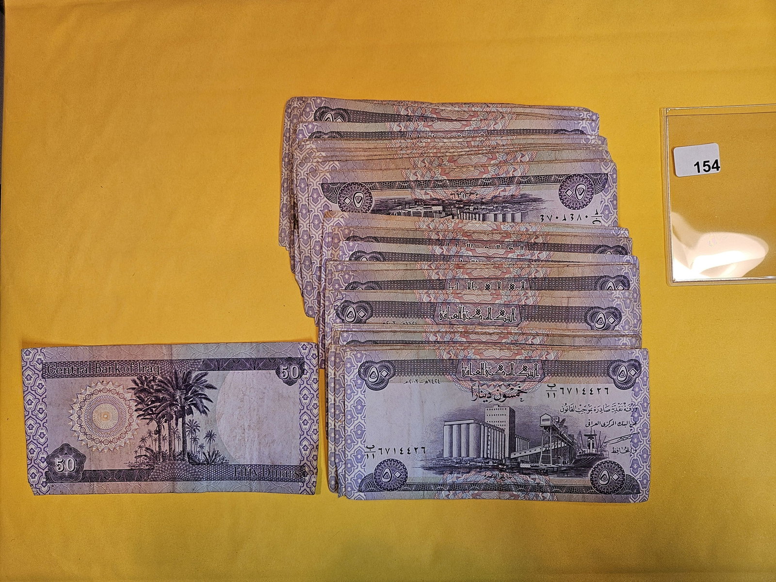 Stack of FIFTY Central Bank of Iraq 50 dinars: Colorful notes. All lightly circulated