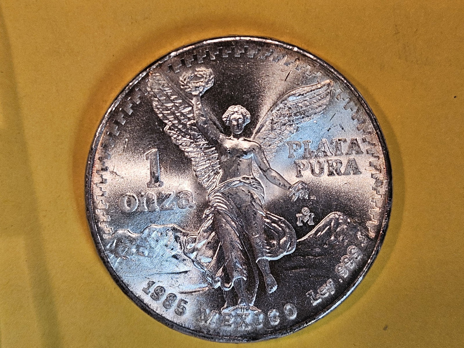 GEM Brilliant Uncirculated 1985 Mexico silver one Onza: Libertad. Lightly toned