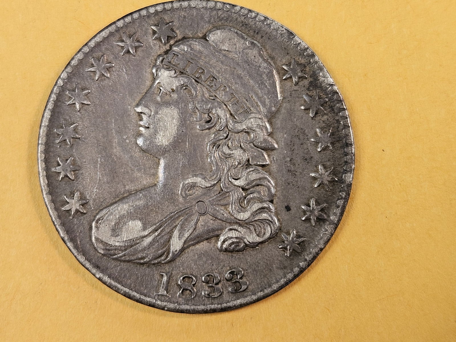1833 Capped Bust Half Dollar in Extra Fine plus: Has a cool planchet flaw on the reverse 