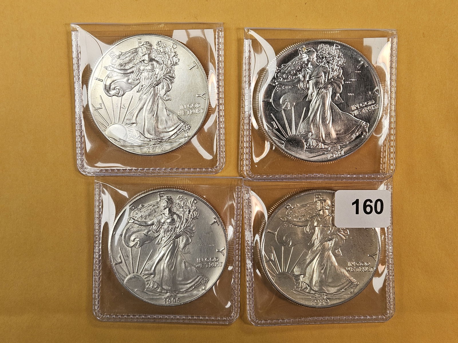 Four mixed American Silver Eagles: Mixed dates and grades 