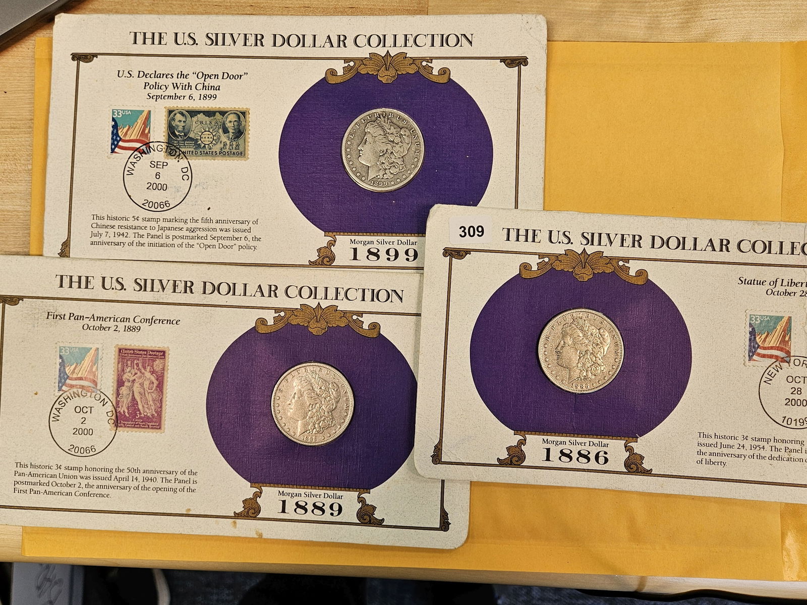 Three US Morgan Silver Dollars: In educational folio holders 